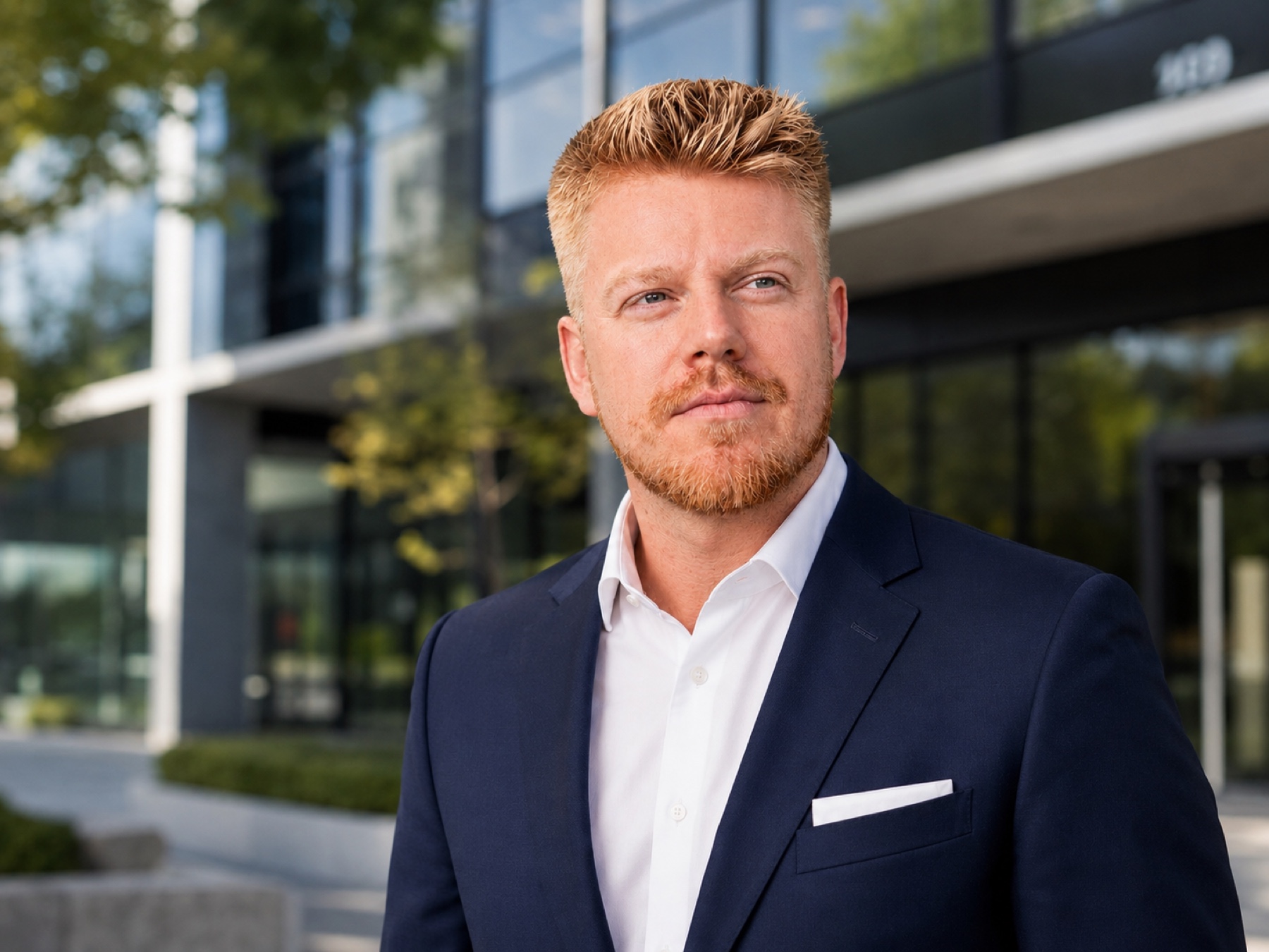 Michael Mares in a navy suit outside a modern office building